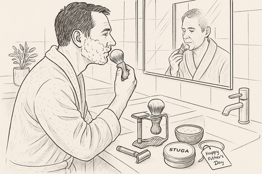 Man applying shaving cream with Stuga shaving brush in front of mirror – traditional shaving kit with razor, brush, soap and Happy Father’s Day gift tag on bathroom counter