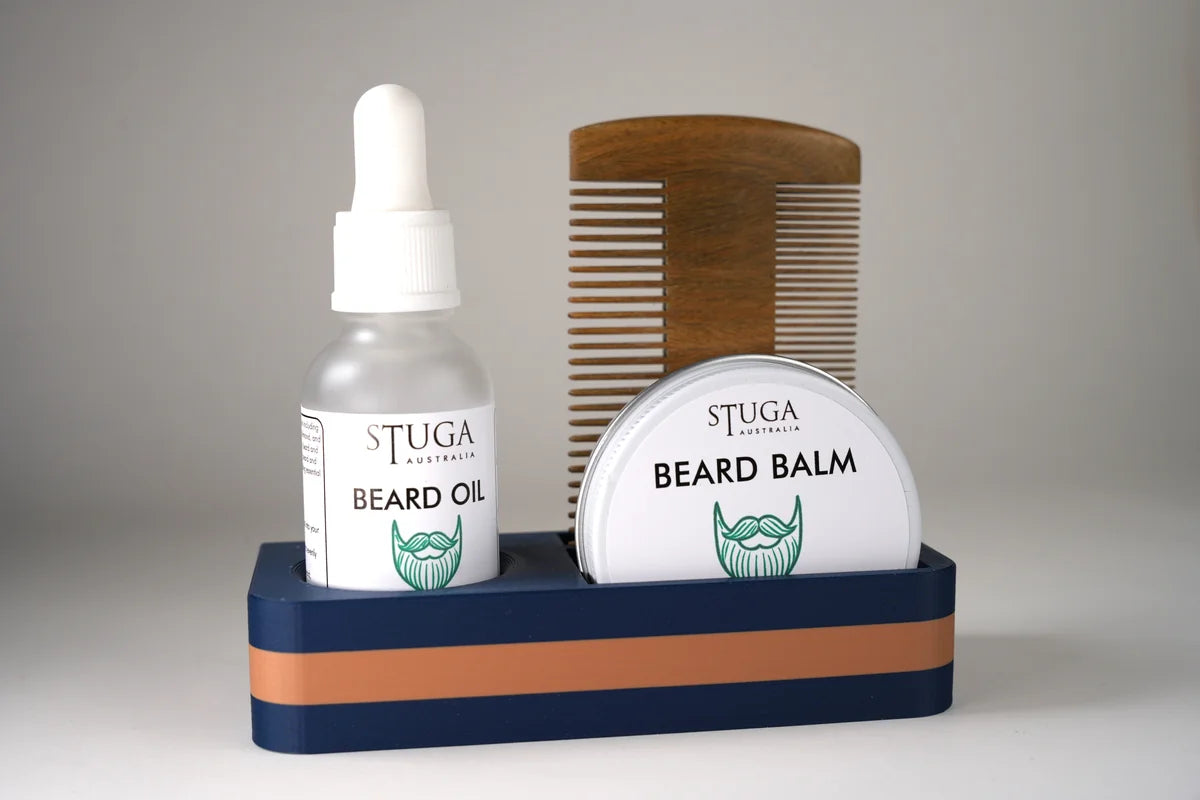 Stuga Australia beard care set with beard oil, beard balm in metal tin, and wooden comb in navy and brown holder