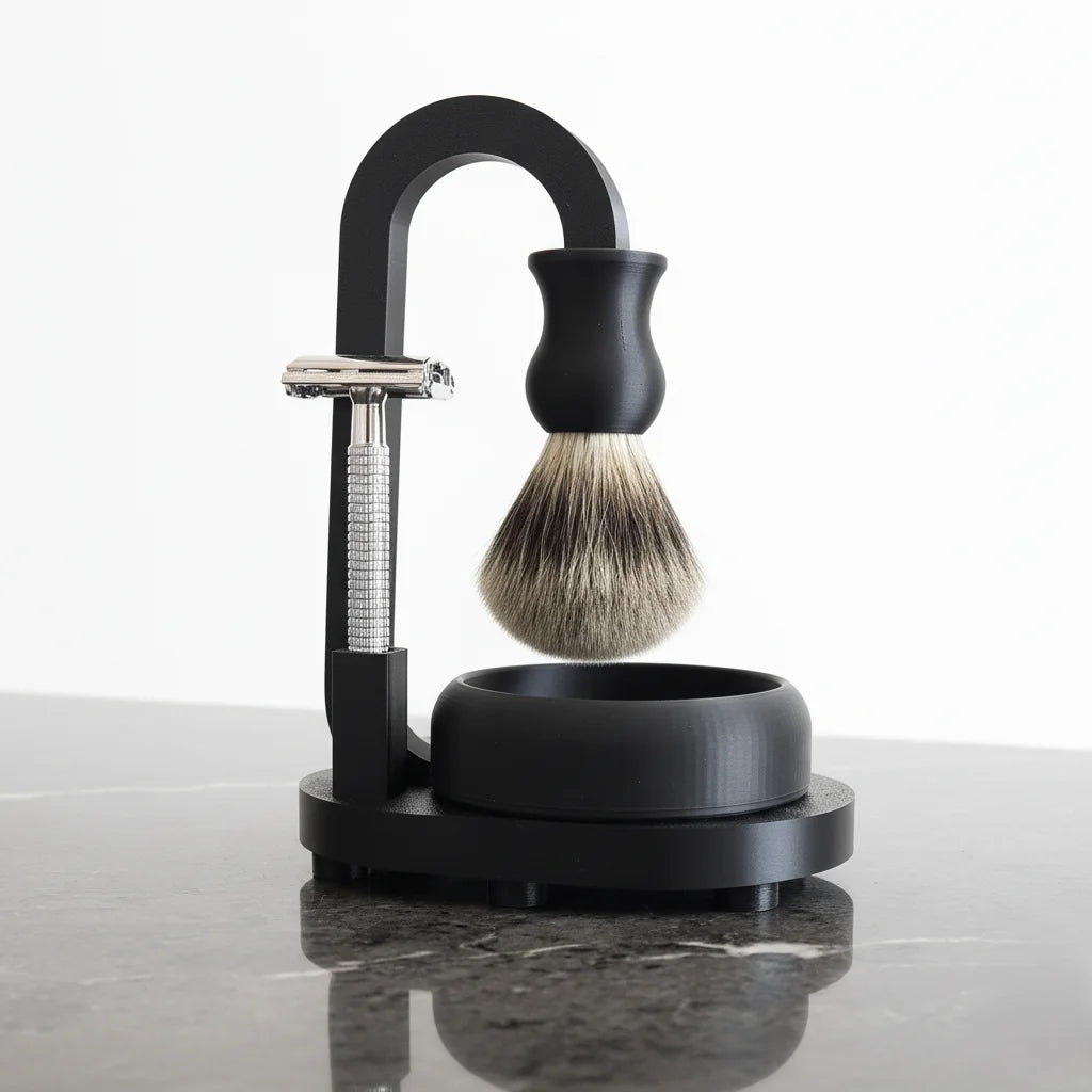 Black shaving stand with safety razor, badger hair brush, and bowl on a marble counter.