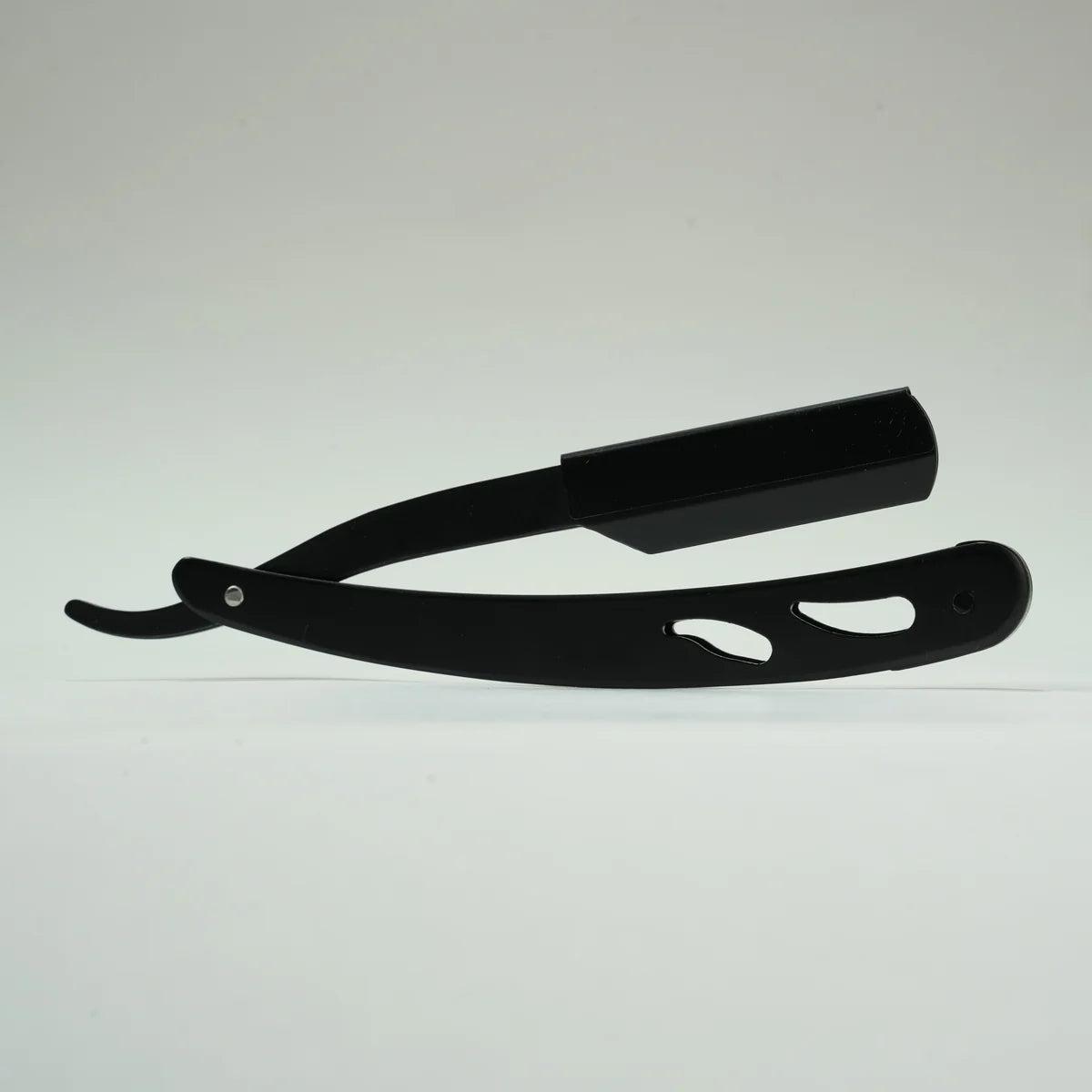 Black straight razor with cut-out handle design for precise shaving and grooming
