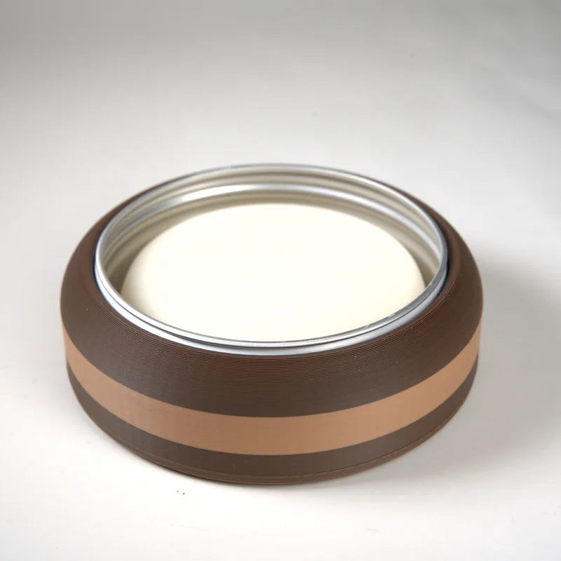 Round brown and beige candle container with white wax, suitable for home decor and relaxation