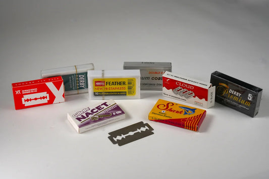 Assorted double edge razor blades in various branded packaging including Feather, Derby, Gillette, Shark, and Cloud for shavi