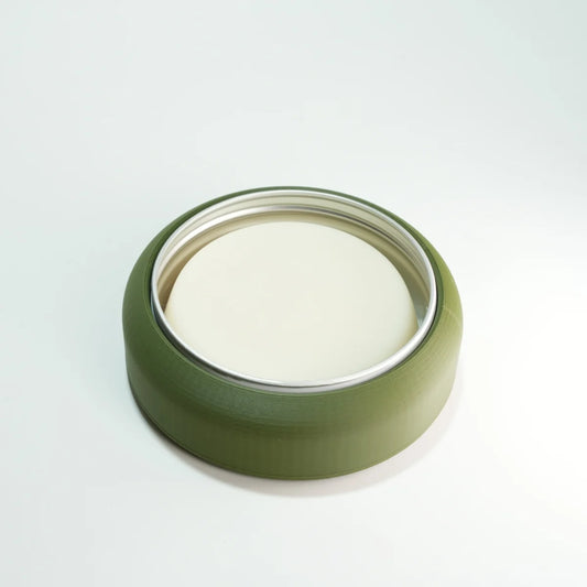 green shaving bowl with a metal tin and shaving soap in it