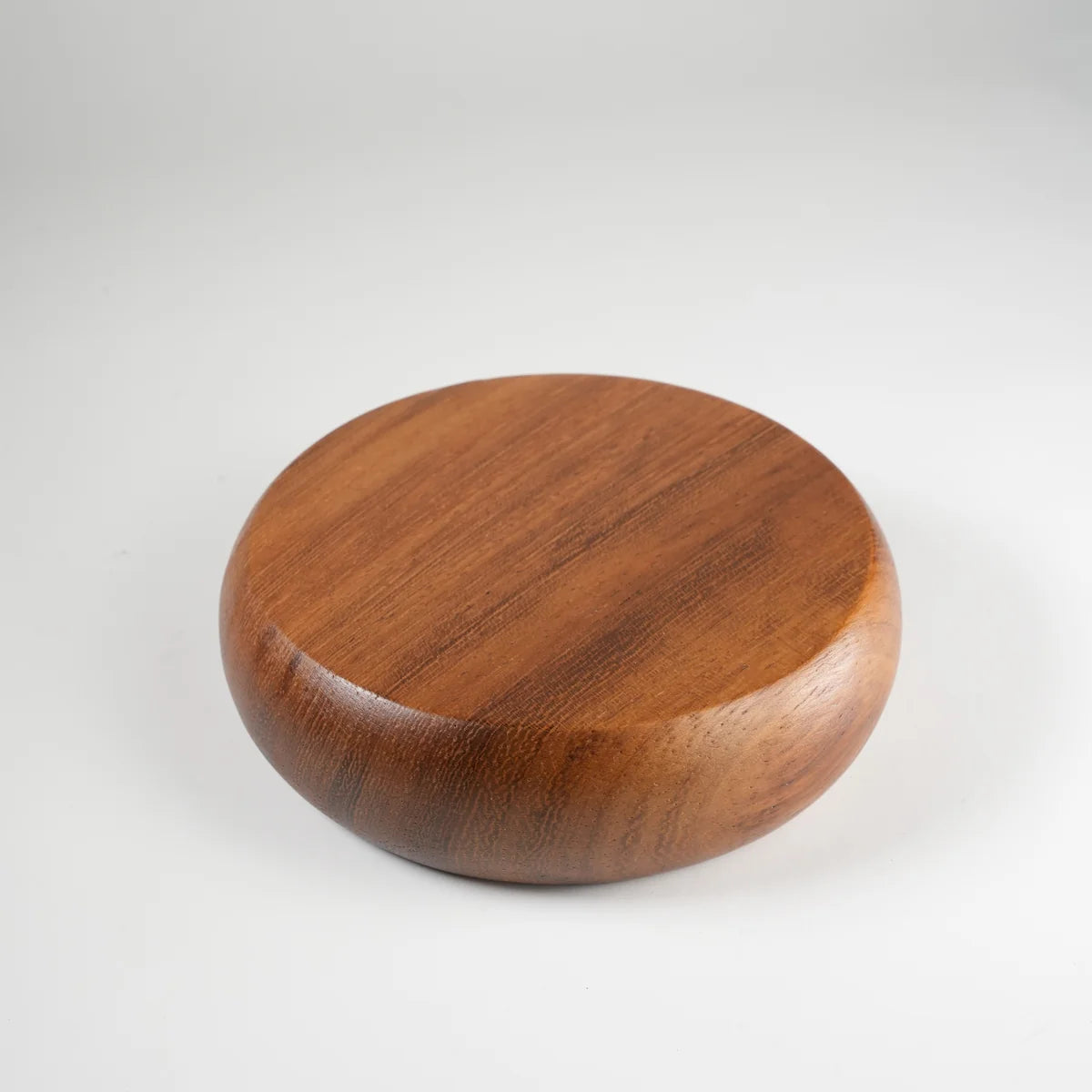 Round teak wood coaster with smooth finish and natural grain, ideal for protecting surfaces from drink stains