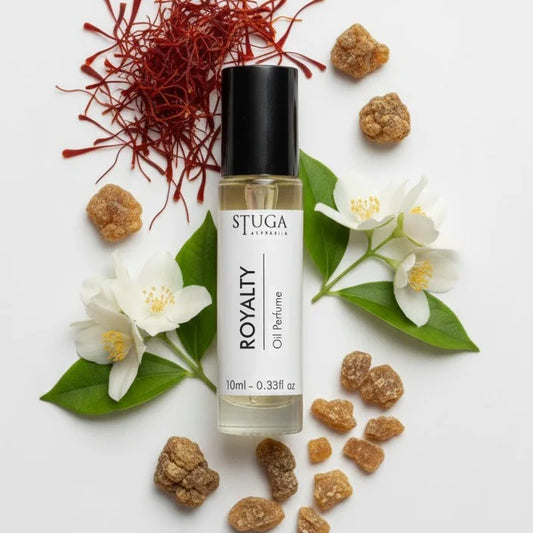 10ml Stuga Royalty oil perfume bottle surrounded by white jasmine flowers, green leaves, saffron strands, and brown resin pie