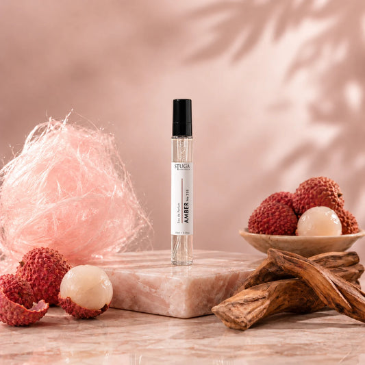 Stuga Amber No. 235 amber perfume, 10ml eau de parfum spray bottle on pink marble with spun sugar, lychees and amberwood.