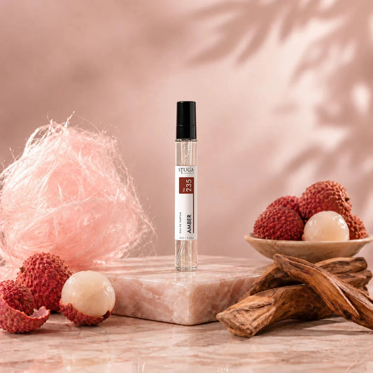 Stuga Amber No. 235 amber perfume, 10ml eau de parfum spray bottle on pink marble with spun sugar, lychees and amberwood.