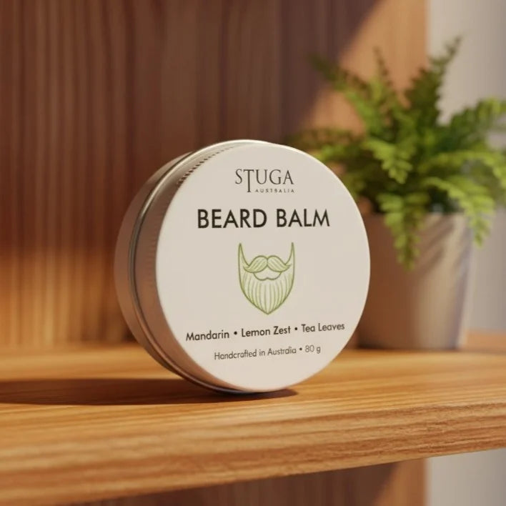 Stuga Australia Beard Balm with mandarin, lemon zest, and tea leaves in a round silver tin on a wooden shelf.