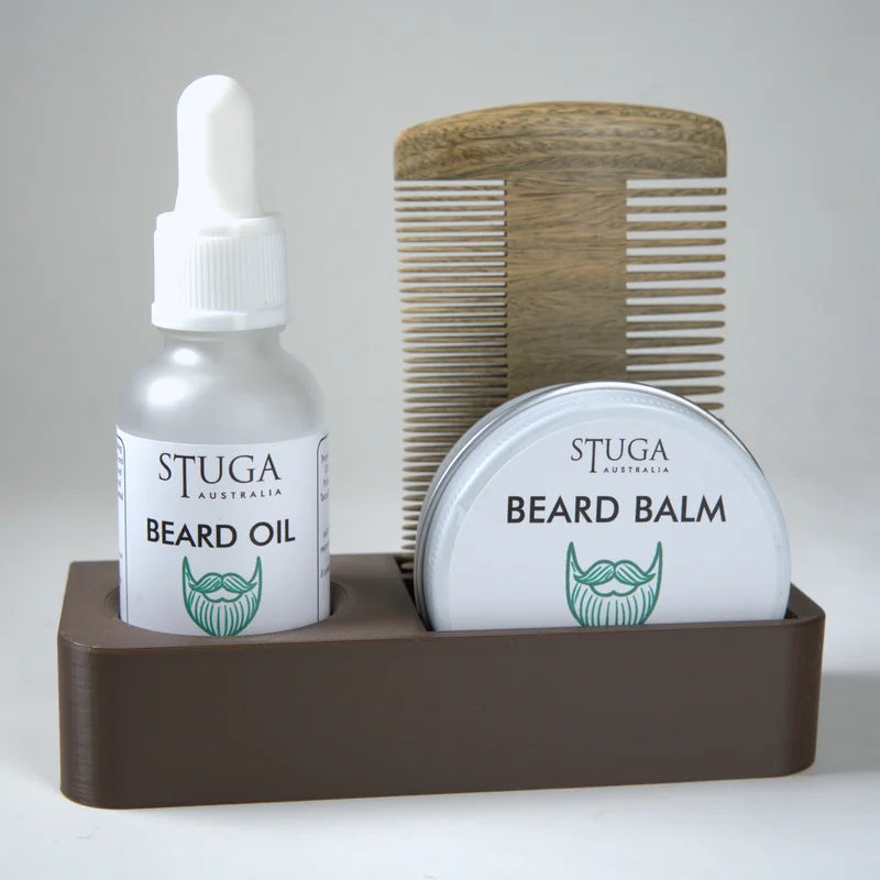 Stuga Australia beard oil and beard balm in white containers with green logo, wooden beard comb, all in brown holder