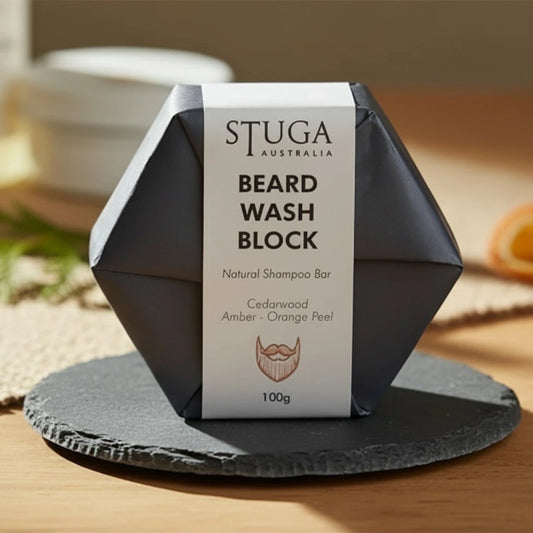 Stuga Australia Beard Wash Block, natural shampoo bar with cedarwood, amber, and orange peel, 100g, on a slate coaster.