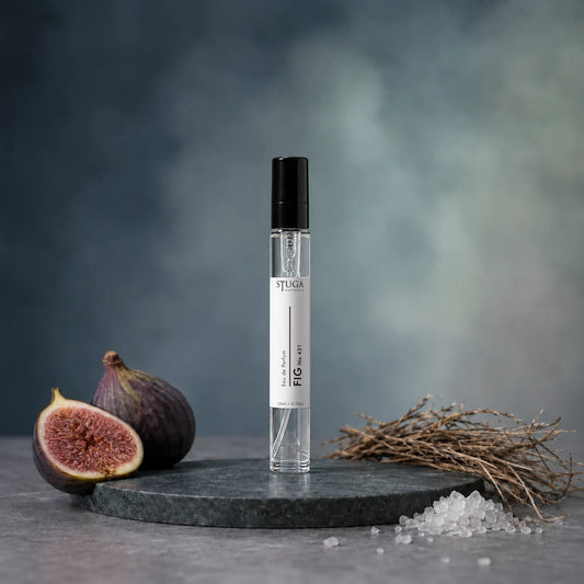 Stuga Fig No. 431 fig perfume, 10ml eau de parfum spray bottle on a dark green marble plinth with fresh figs, dried grass and sea salt.