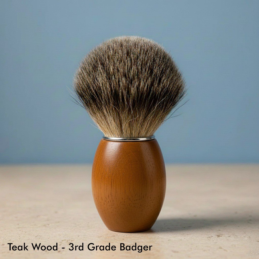 Close-up of a shaving brush with a smooth, light brown teak wood handle and soft, dark brown 3rd grade badger bristles.