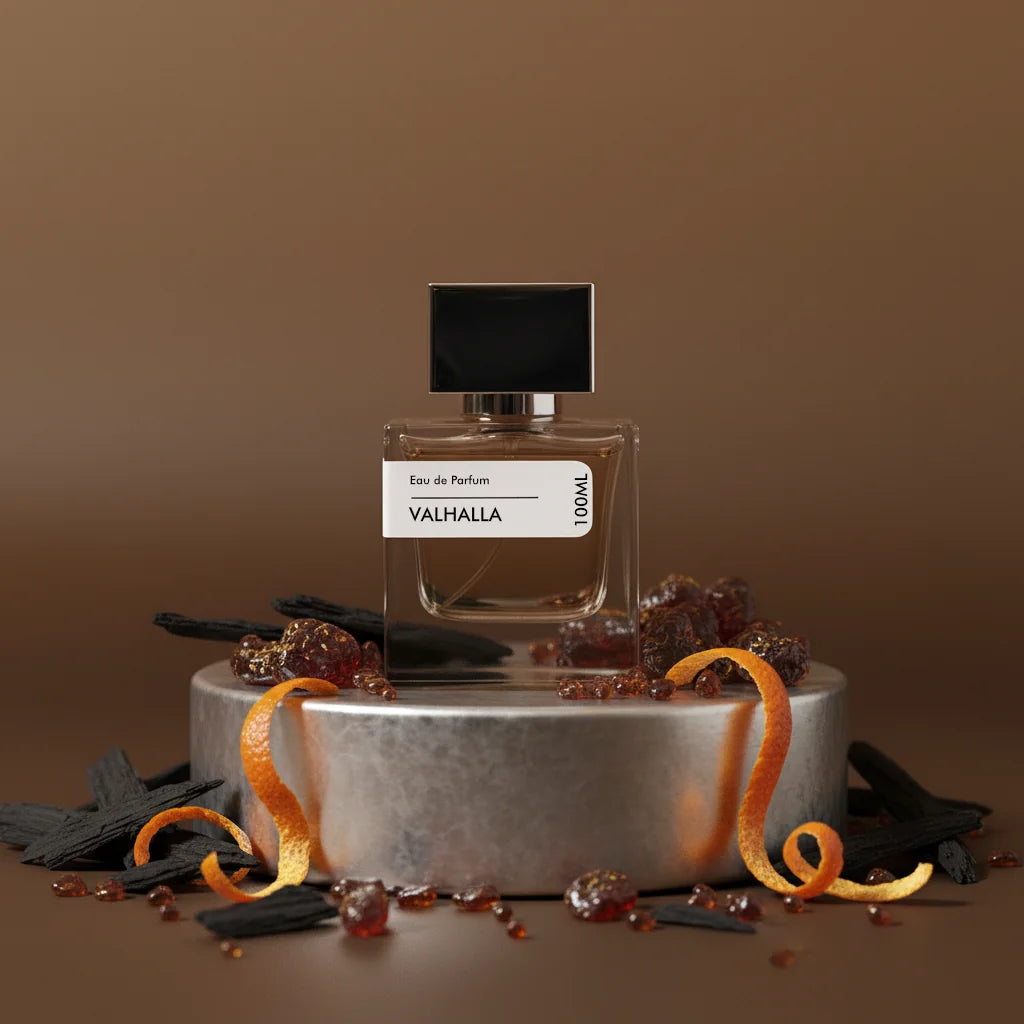 Valhalla Eau de Parfum 100ml bottle with black cap, surrounded by wood chips, amber crystals, and orange peels on a silver pe