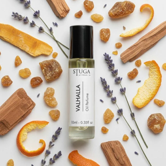 Valhalla oil perfume by Stuga Australia in 10ml roll-on bottle surrounded by dried lavender, orange peel, amber resin, and wo