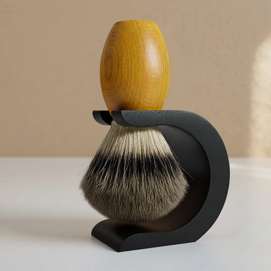 Wooden handle shaving brush with badger hair bristles, resting in a sleek black metal stand.