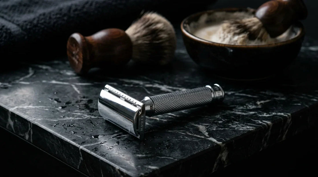 Premium double edge safety razor on dark marble surface with shaving brush and soap