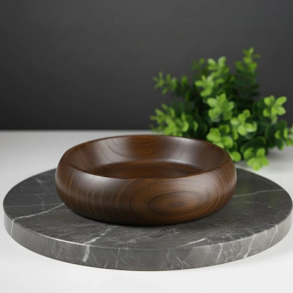 Dark brown ash wood shaving bowl with smooth finish, resting on a grey marble slab.