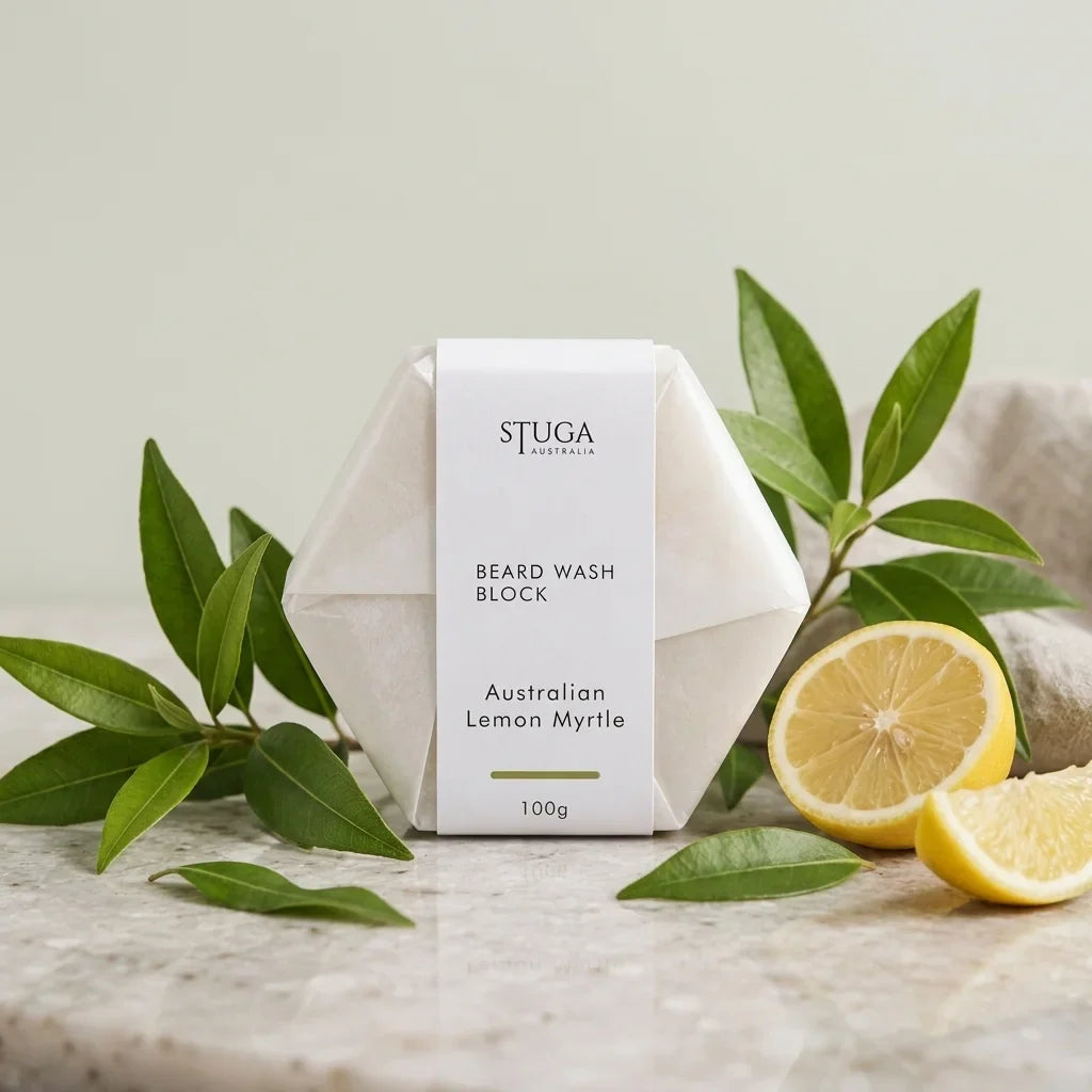 Stuga Australia Beard Wash Block, natural shampoo bar scented with Australian lemon myrtle, 100g, with fresh lemon and myrtle leaves on a stone benchtop.