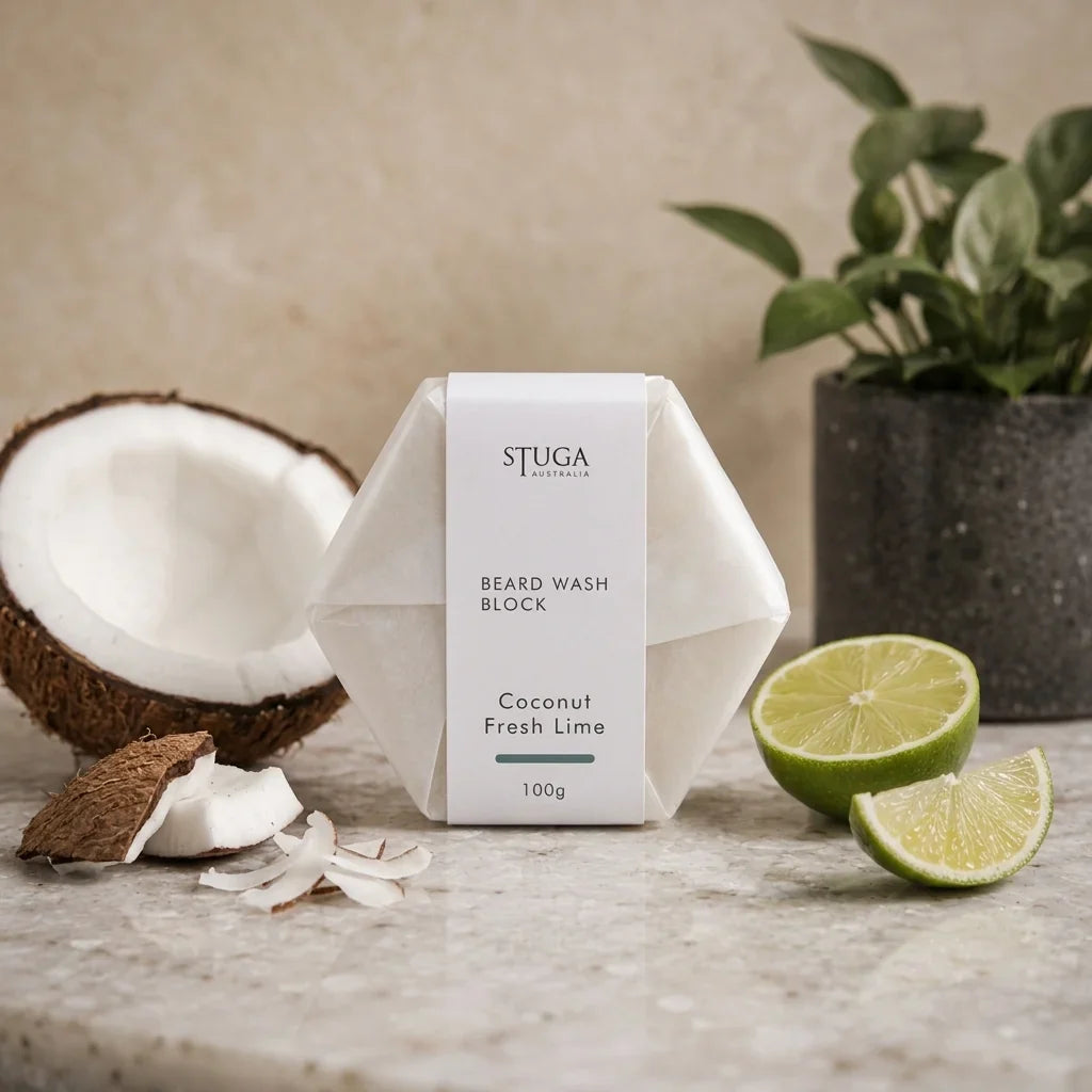 Stuga Australia Beard Wash Block, natural shampoo bar scented with coconut and fresh lime, 100g, with fresh coconut and lime on a stone benchtop.
