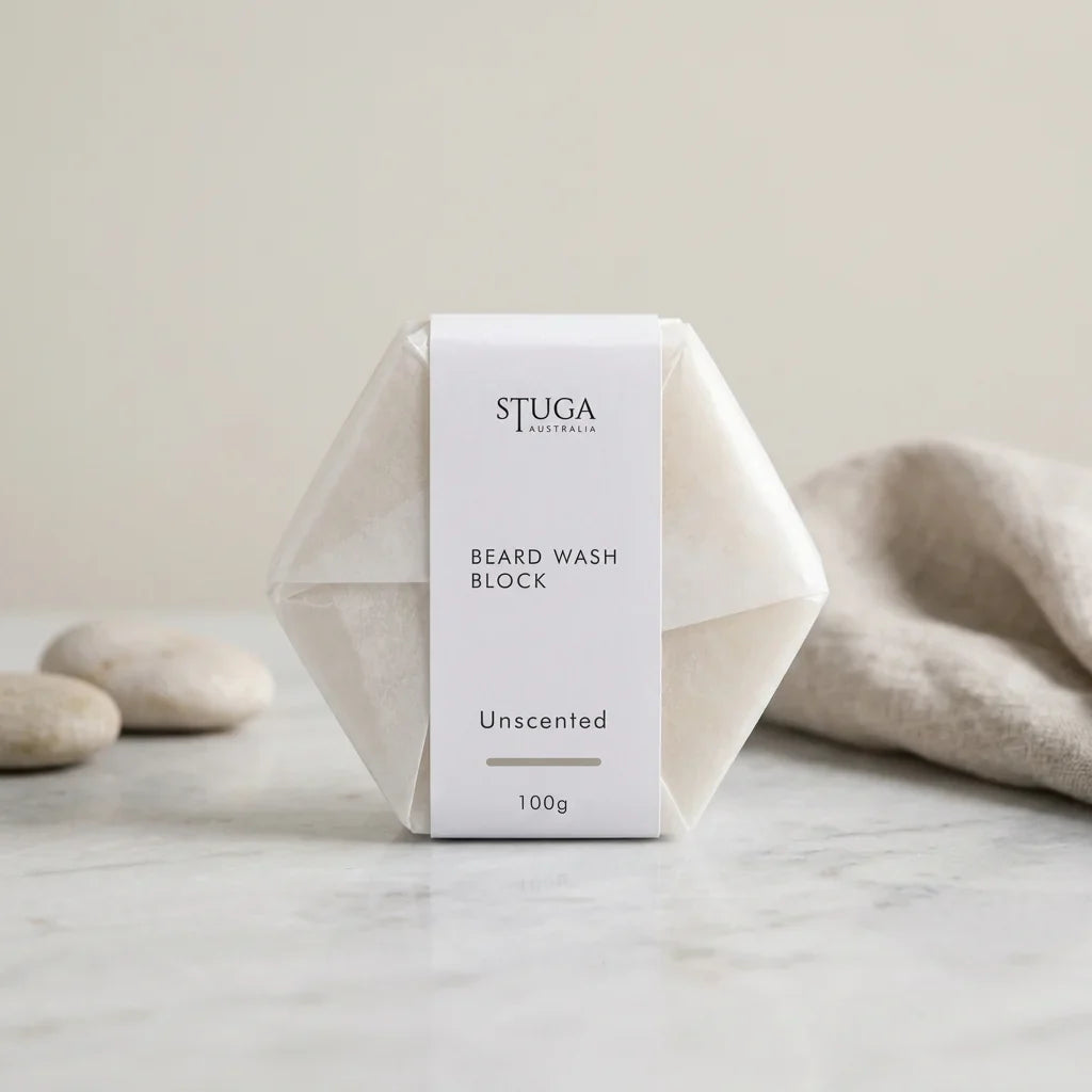 Stuga Australia Beard Wash Block, unscented natural shampoo bar, 100g, with smooth pebbles and a linen towel on a stone benchtop.