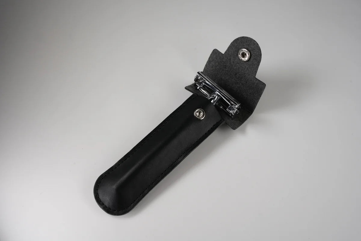 Black leather razor holder with snap closure and metal clip for secure storage and travel protection