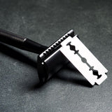 WÖLFE 97 three-piece DE safety razor shown with handle, base plate and cap, in matte black.