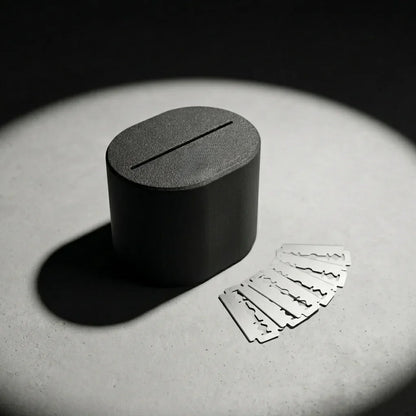 Stuga Blade Bank sealed matte charcoal razor blade disposal case on concrete