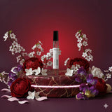 Stuga Desire Eau de Parfum 10ml rollerball bottle, surrounded by red peonies, white cherry blossoms, and purple sweet peas on