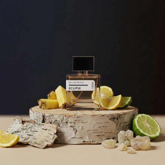 Eclipse Eau de Parfum 100ml in square glass bottle with black cap, displayed with citrus and pineapple accents