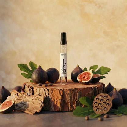 Stuga Horizon Eau de Parfum 10ml travel spray in clear glass vial with black cap, styled with fresh figs and wood