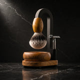 Luxury Magic Shaving Kit in teak — silver tip badger brush with teak handle suspended from black arch stand, handturned teak bowl and base with safety razor on black marble