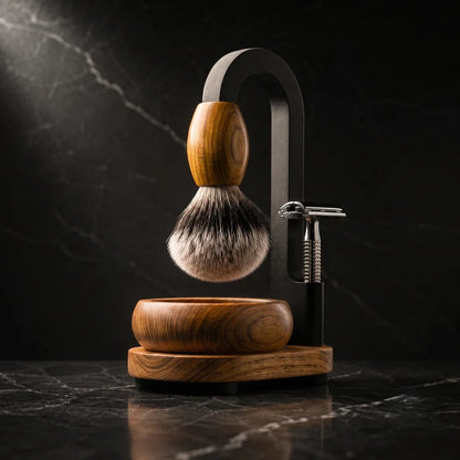 Luxury Magic Shaving Kit in teak — silver tip badger brush with teak handle suspended from black arch stand, handturned teak bowl and base with safety razor on black marble