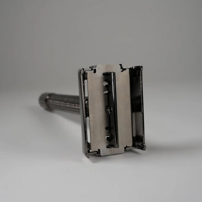 Close-up of a metal double edge safety razor with a textured handle for precise shaving