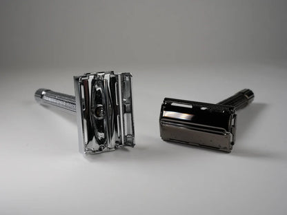 Two chrome metal double edge safety razors with textured handles for precise shaving