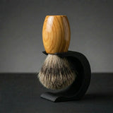 Olive wood handle Essentials badger bristle shaving brush on a matte black Wave stand, Australian made by Stuga.