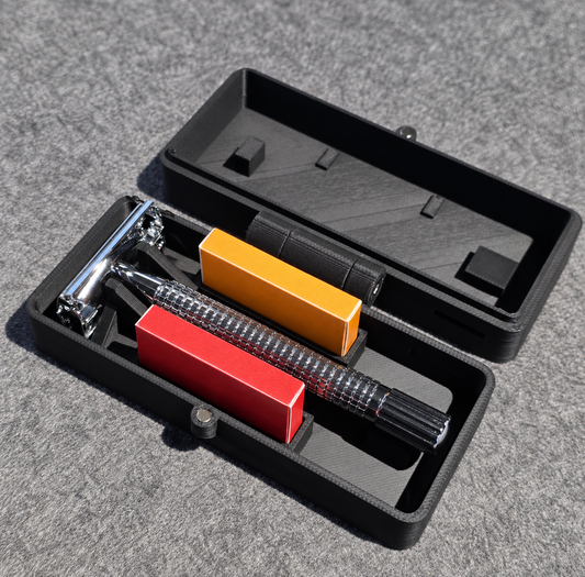 Stuga safety razor travel case open, with a double edge safety razor in the fitted cradle and two DE blade packs in the slots