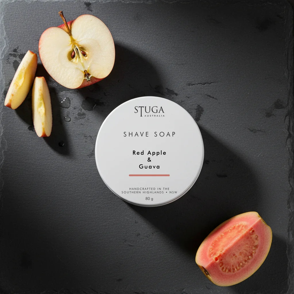Stuga Australia Red Apple & Guava shave soap in a white 80g tin on dark slate with fresh fruit