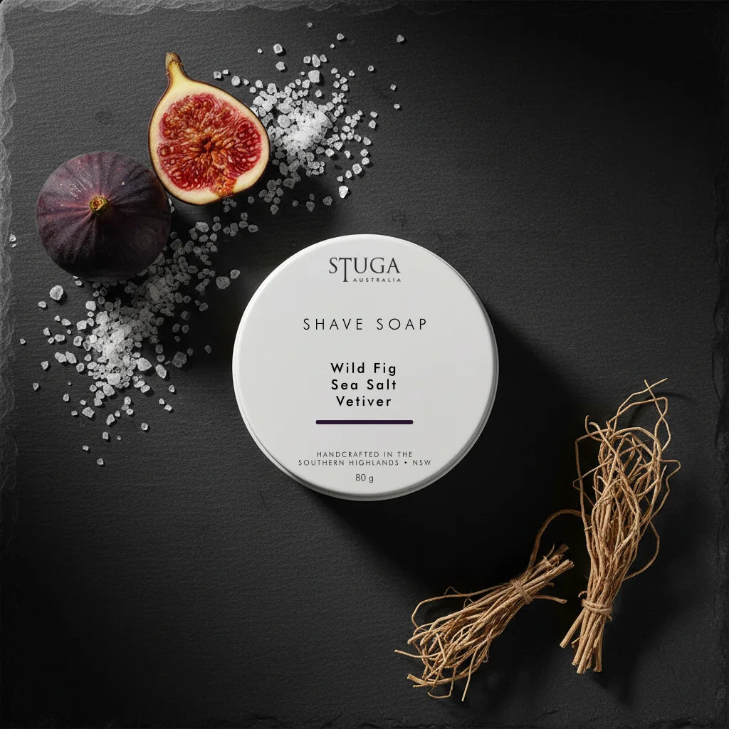 White circular shave soap container with 'Wild Fig Sea Salt Vetiver' text, surrounded by figs and sea salt.