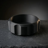 Faceted black shaving bowl with ridged grip sides on dark slate, wide lathering well for shave soap