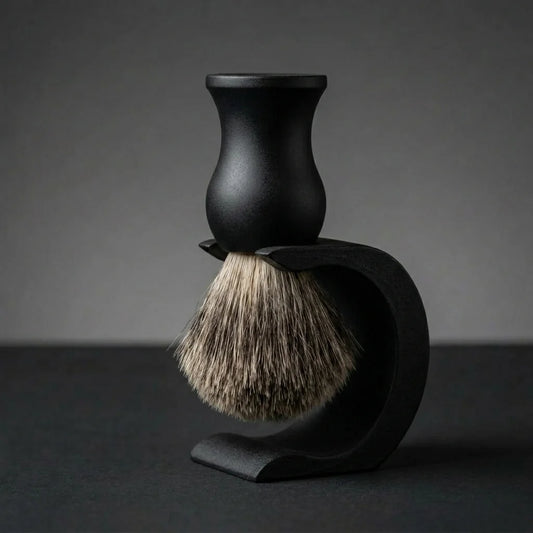 Badger hair shaving brush with matte black handle displayed on a matching black drip stand