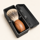 Stuga shaving brush travel case open, with a timber-handled badger shaving brush resting on the ribbed cradle