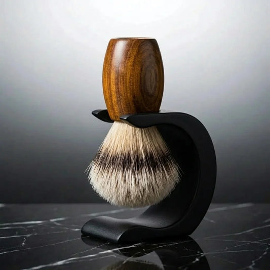 Shaving brush with polished wooden handle and silvertip bristles displayed on a curved matte black metal stand