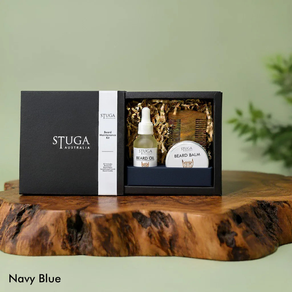 Stuga Australia Beard Maintenance Kit in navy blue box with beard oil, balm, and wooden comb on a wood slab.