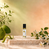 Stuga Bergamot No. 353 bergamot oil perfume, 10ml roll-on bottle on travertine with green bergamots, orange blossom and leafy sprigs in warm sunlight.