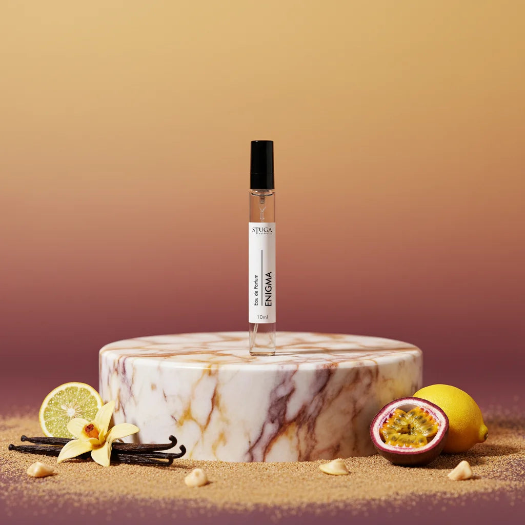 Stuga Enigma 10ml Eau de Parfum bottle on a marble pedestal, surrounded by vanilla beans, lemon, passion fruit, and brown sug