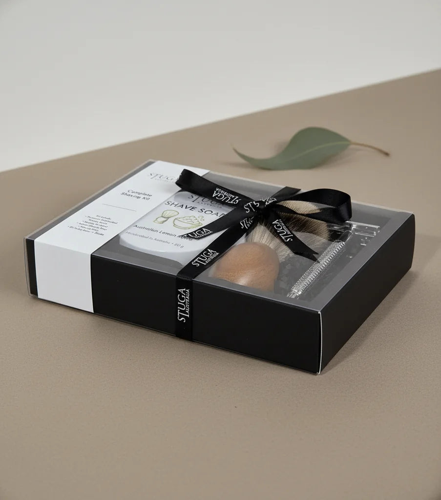 Stuga handmade complete shaving kit in a clear gift box with black ribbon, featuring a shaving brush, razor, and shave soap.