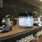 Sandalwood No. 413 10ml eau de parfum sprays in a glass jar beside a tester bottle on the Stuga shelf