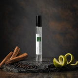 Stuga Sandalwood No. 413 sandalwood perfume, 10ml eau de parfum spray bottle on slate with sandalwood sticks, black peppercorns and a lime peel twist.