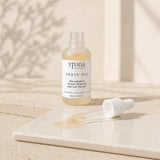 Open 30ml Stuga shave oil bottle with dropper and pale golden oil on a glossy tile