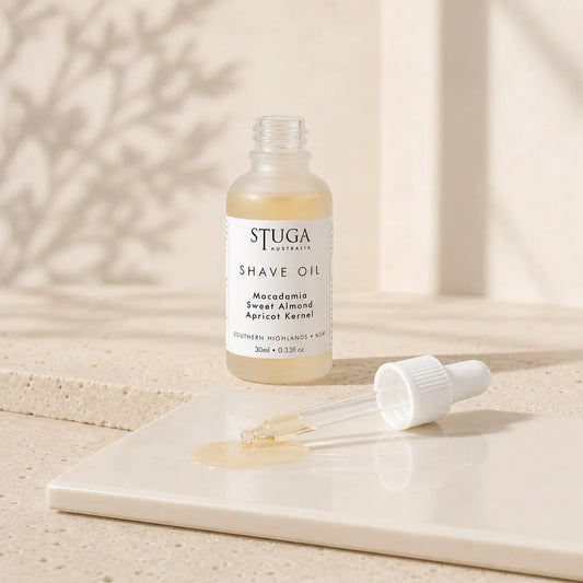Open 30ml Stuga shave oil bottle with dropper and pale golden oil on a glossy tile